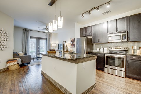 a kitchen with stainless steel appliances and an island with granite counter tops